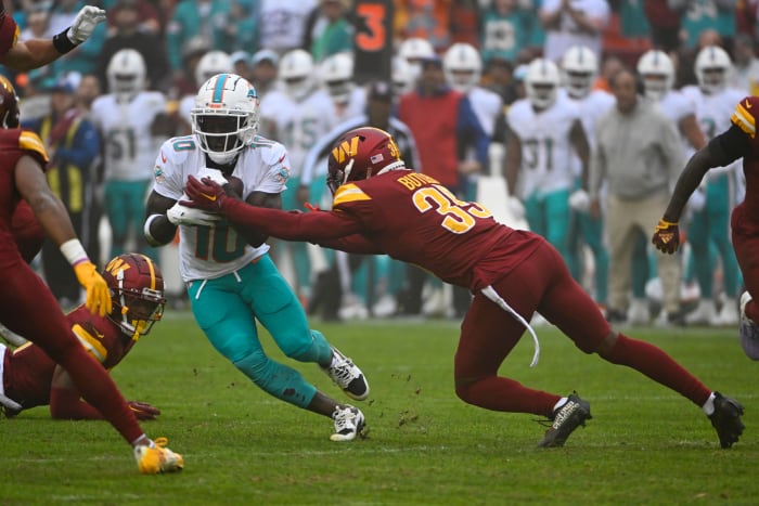 Miami Dolphins wide receiver Tyreek Hill (10) runs after a catch as Washington Commanders safety Percy Butler (35) defends during the first half at FedExField.